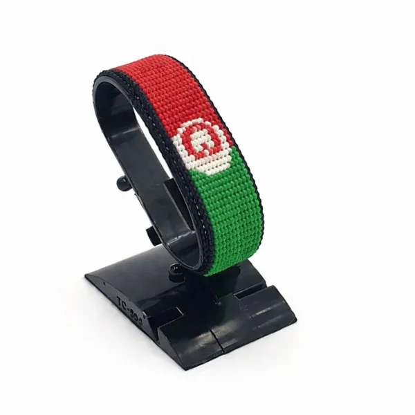 Handcrafted Afghanistan flag bracelet made with red, black, and green beads, adjustable beaded wrist accessory, displayed on a black stand.