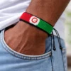 Model wearing a handcrafted Afghanistan flag bracelet made with red, black, and green beads, adjustable beaded wrist accessory.