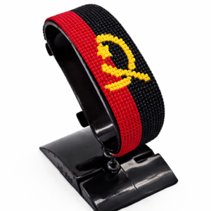 Handcrafted Angola flag bracelet made with red, black, and yellow beads, adjustable beaded wrist accessory, displayed on a black stand.