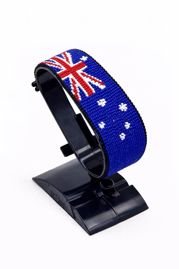 Handcrafted Australia flag bracelet made with blue, red, and white beads, featuring a custom name, adjustable beaded wrist accessory, displayed on a black stand.