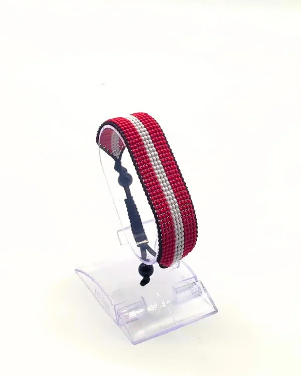 Handcrafted Austria flag bracelet made with red and white beads, adjustable beaded wrist accessory, displayed on a Clear stand.