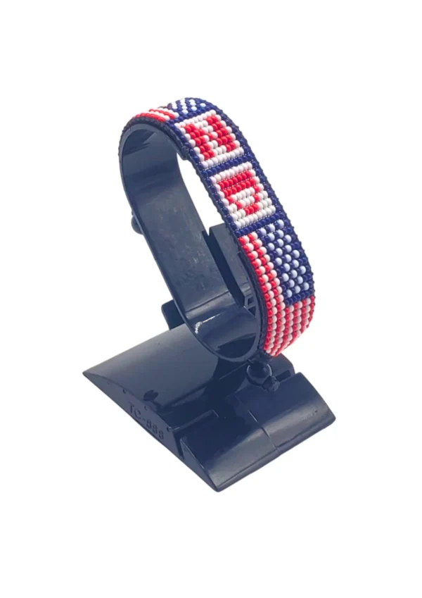 Handcrafted USA flag bracelet made with red and white beads, adjustable beaded wrist accessory, displayed on a black stand.