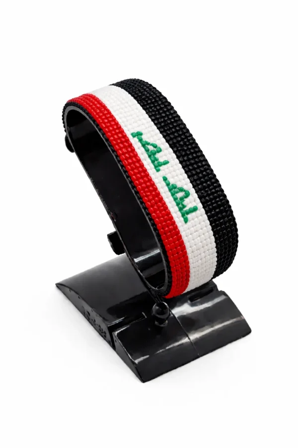 Handcrafted Iraq flag bracelet made with red and white beads, adjustable beaded wrist accessory, displayed on a black stand