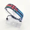 Handcrafted Kenya flag bracelet made with red and white beads, adjustable beaded wrist accessory, displayed on a Clear stand