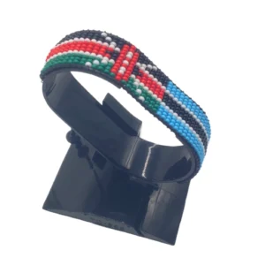 Handcrafted Kenya flag bracelet made with red and white beads, adjustable beaded wrist accessory, displayed on a black stand