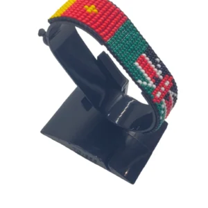 Handcrafted Kenya flag bracelet made with red and white beads, adjustable beaded wrist accessory, displayed on a black stand
