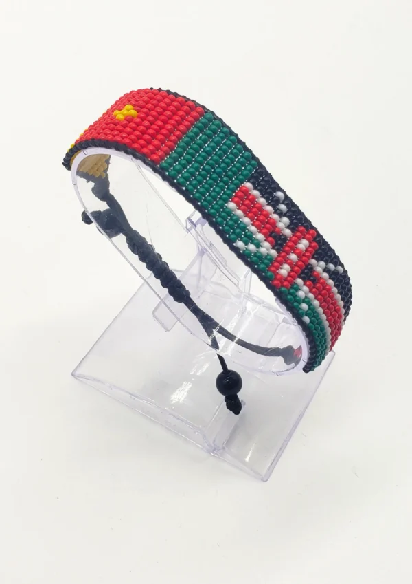 Handcrafted Kenya flag bracelet made with red and white beads, adjustable beaded wrist accessory, displayed on a Clear stand