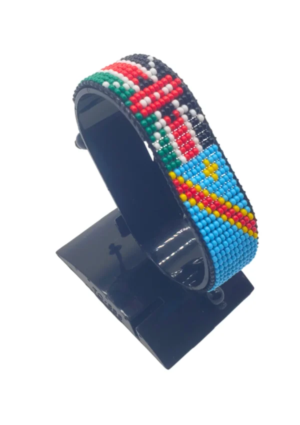 Handcrafted Kenya flag bracelet made with red and white beads, adjustable beaded wrist accessory, displayed on a black stand