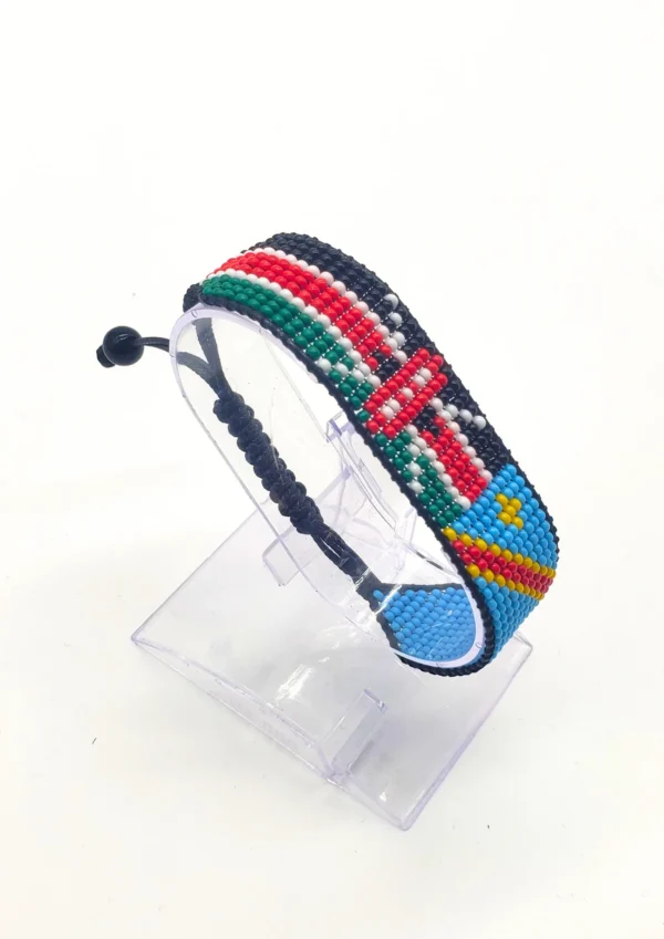 Handcrafted Kenya flag bracelet made with red and white beads, adjustable beaded wrist accessory, displayed on a Clear stand