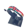 Handcrafted Kenya flag bracelet made with red and white beads, adjustable beaded wrist accessory, displayed on a black stand