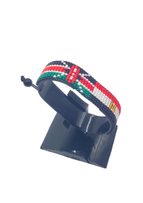 Handcrafted Kenya flag bracelet made with red and white beads, adjustable beaded wrist accessory, displayed on a black stand