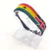 Handcrafted Kenya Egypt flag bracelet made with red and white beads, adjustable beaded wrist accessory, displayed on a Clear stand