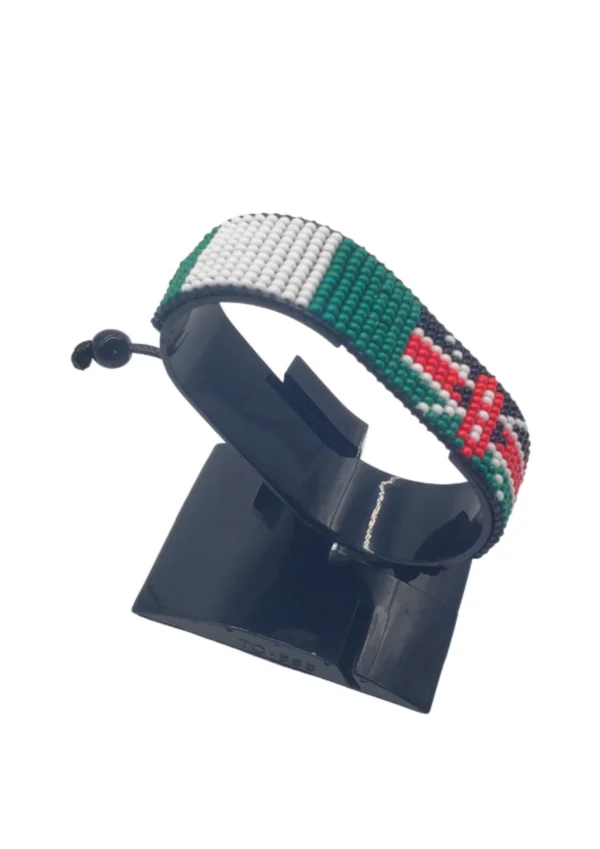 Handcrafted Kenya flag bracelet made with red and white beads, adjustable beaded wrist accessory, displayed on a black stand