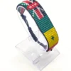 Handcrafted Kenya Senegal flag bracelet made with red and white beads, adjustable beaded wrist accessory, displayed on a Clear stand