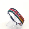 Handcrafted Kenya Uganda flag bracelet made with red and white beads, adjustable beaded wrist accessory, displayed on a Clear stand