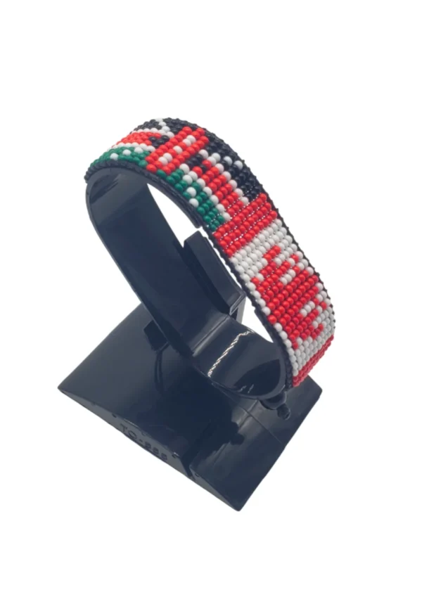 Handcrafted Kenya flag bracelet made with red and white beads, adjustable beaded wrist accessory, displayed on a black stand