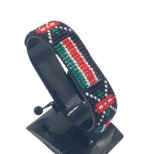 Handcrafted Kenya flag bracelet made with red and white beads, adjustable beaded wrist accessory, displayed on a black stand