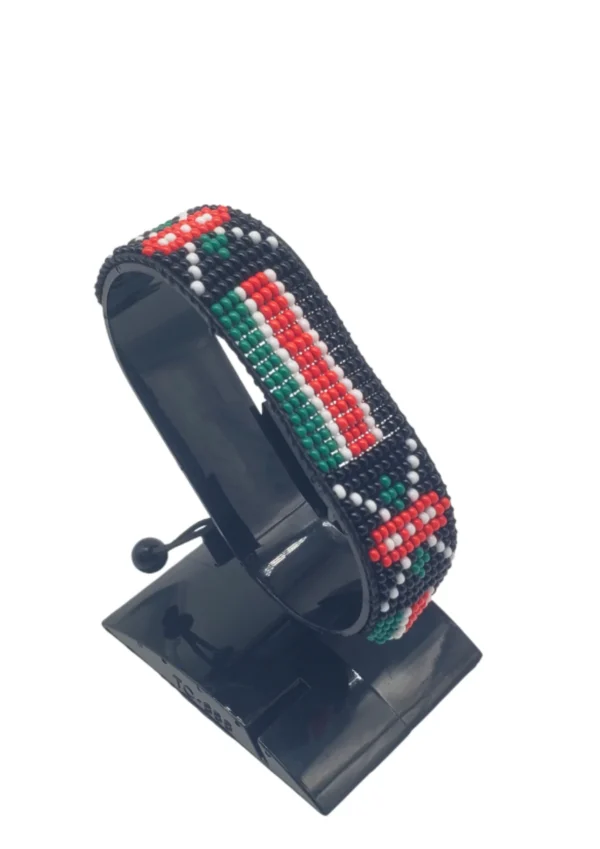 Handcrafted Kenya flag bracelet made with red and white beads, adjustable beaded wrist accessory, displayed on a black stand