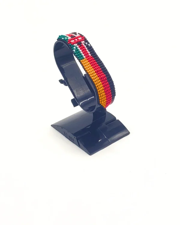 Handcrafted Kenya Germany flag bracelet made with red and white beads, adjustable beaded wrist accessory, displayed on a black stand