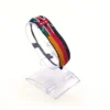 Handcrafted Kenya Germany flag bracelet made with red and white beads, adjustable beaded wrist accessory, displayed on a clear stand