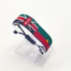 Handcrafted Kenya Morocco flag bracelet made with red and white beads, adjustable beaded wrist accessory, displayed on a clear stand