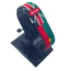 Handcrafted Kenya Morocco flag bracelet made with red and white beads, adjustable beaded wrist accessory, displayed on a black stand
