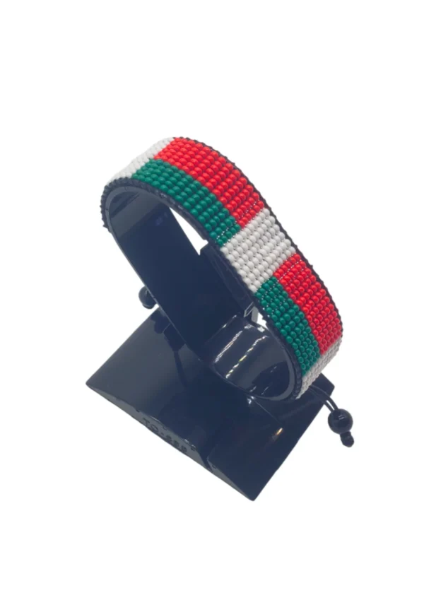 Handcrafted Madagascar flag bracelet made with red and white beads, adjustable beaded wrist accessory, displayed on a black stand