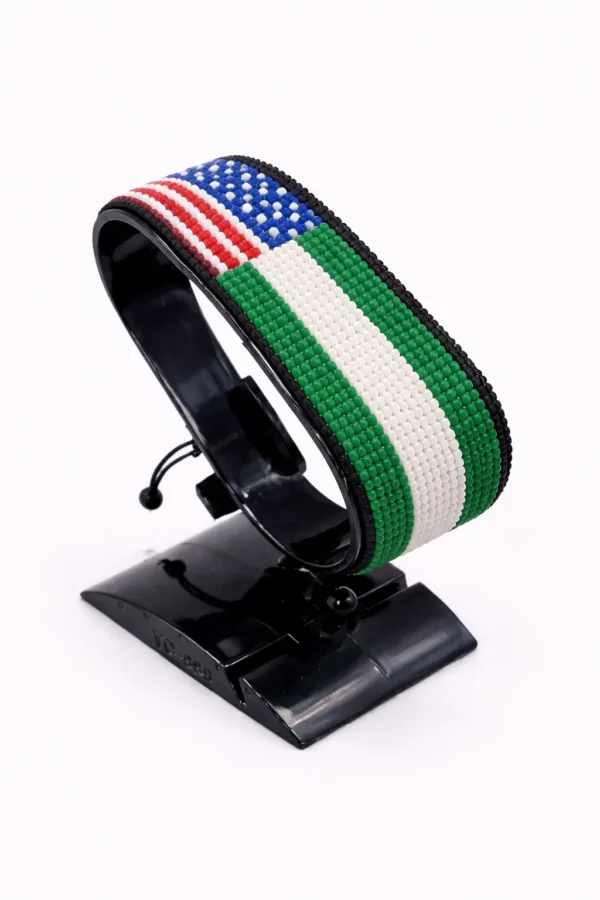 Handcrafted USA Nigeria Combo flag bracelet made with red and white beads, adjustable beaded wrist accessory, displayed on a Clear stand.