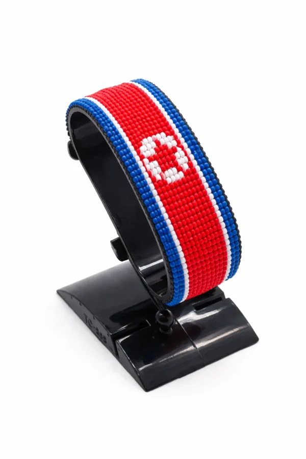 Handcrafted North Korea flag bracelet made with red and white beads, adjustable beaded wrist accessory, displayed on a black stand