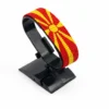 Handcrafted North Macedonia flag bracelet made with red and white beads, adjustable beaded wrist accessory, displayed on a black stand