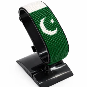 Handcrafted Pakistan flag bracelet made with red and white beads, adjustable beaded wrist accessory, displayed on a black stand