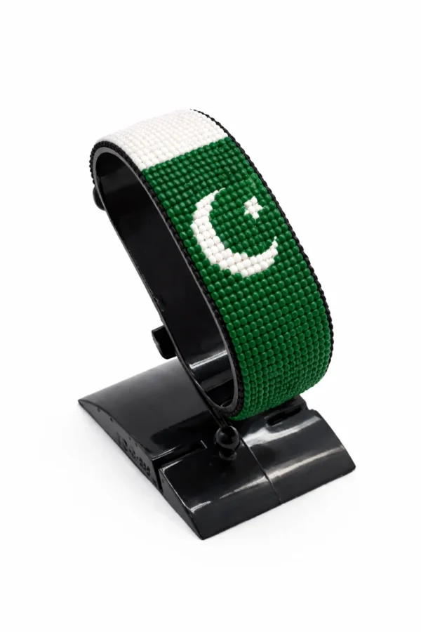 Handcrafted Pakistan flag bracelet made with red and white beads, adjustable beaded wrist accessory, displayed on a black stand