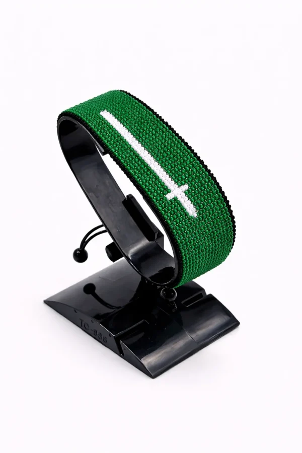 Handcrafted Saudi flag bracelet made with red and white beads, adjustable beaded wrist accessory, displayed on a Black stand