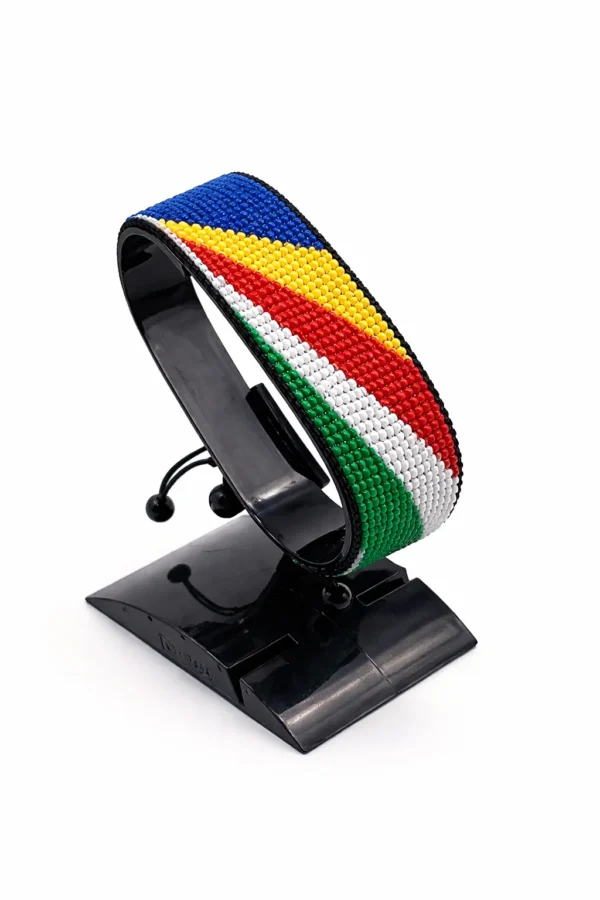 Handcrafted Seychelles flag bracelet made with red and white beads, adjustable beaded wrist accessory, displayed on a black stand