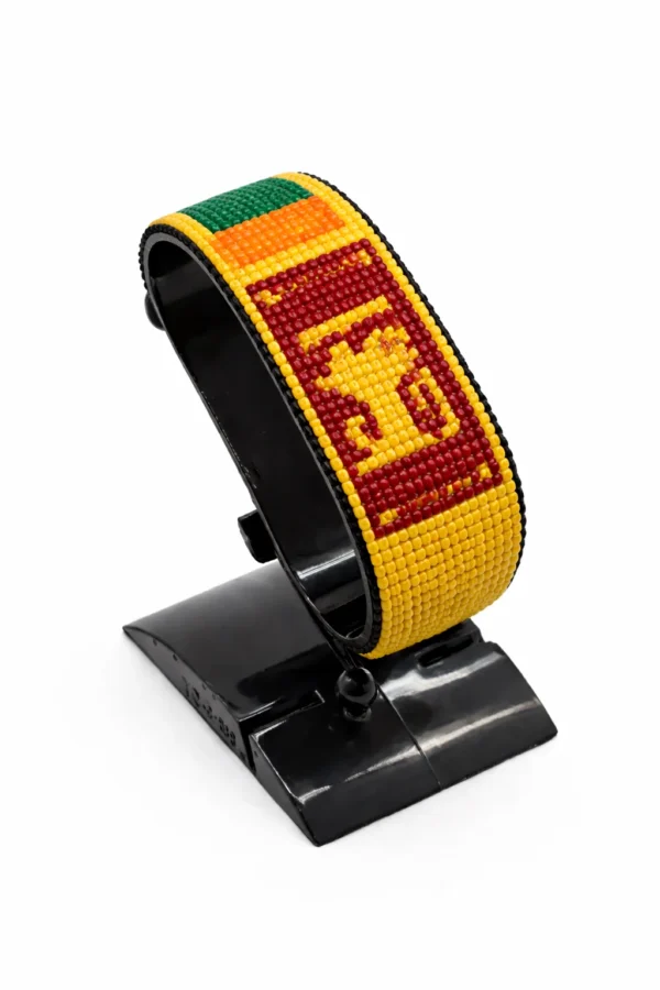 Handcrafted Sri Lanka flag bracelet made with red and white beads, adjustable beaded wrist accessory, displayed on a black stand