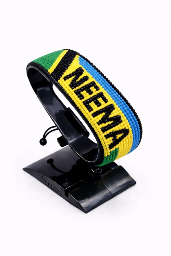 Handcrafted Tanzania with Name flag bracelet, adjustable beaded wrist accessory, displayed on a black stand.