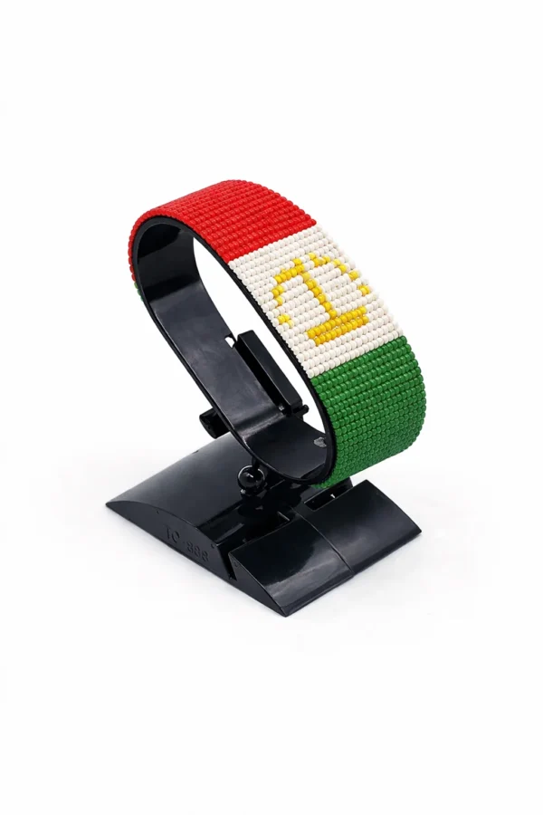 Handcrafted Tajikistan flag bracelet, adjustable beaded wrist accessory, displayed on a black stand.