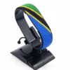 Handcrafted Tanzania flag bracelet, adjustable beaded wrist accessory, displayed on a black stand.