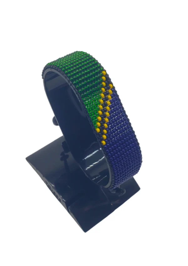 Handcrafted Tanzania flag bracelet, adjustable beaded wrist accessory, displayed on a black stand.
