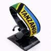 Handcrafted Tanzania with Country Name flag bracelet, adjustable beaded wrist accessory, displayed on a black stand.