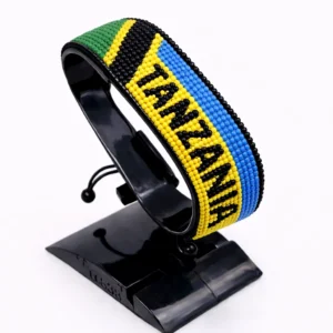 Handcrafted Tanzania with Country Name flag bracelet, adjustable beaded wrist accessory, displayed on a black stand.