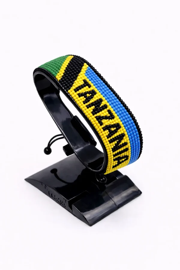 Handcrafted Tanzania with Country Name flag bracelet, adjustable beaded wrist accessory, displayed on a black stand.
