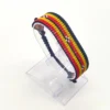 Handcrafted Uganda flag bracelet made with red and white beads, adjustable beaded wrist accessory, displayed on a Clear stand