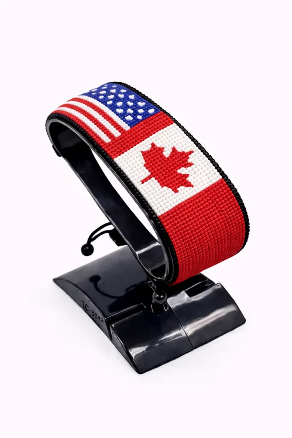 Handcrafted USA CANADA Combo flag bracelet made with red and white beads, adjustable beaded wrist accessory, displayed on a Black stand.