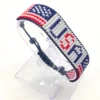 Handcrafted USA flag bracelet made with red and white beads, adjustable beaded wrist accessory, displayed on a Clear stand.