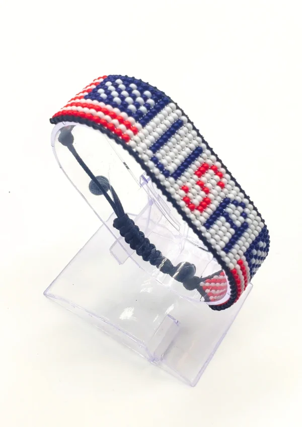 Handcrafted USA flag bracelet made with red and white beads, adjustable beaded wrist accessory, displayed on a Clear stand.