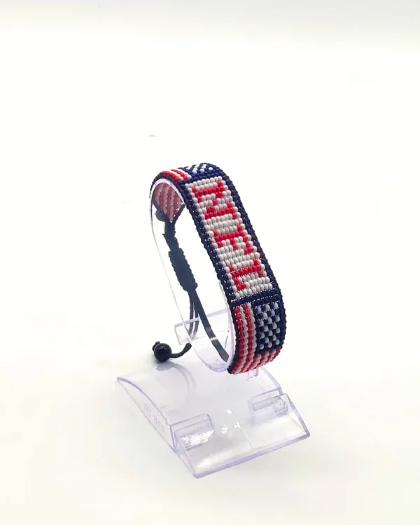 Handcrafted USA flag bracelet made with red and white beads, adjustable beaded wrist accessory, displayed on a Clear stand.