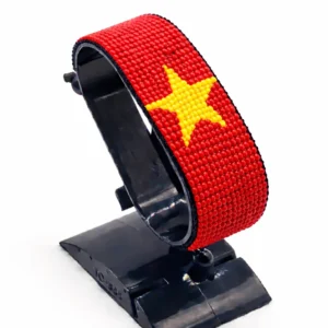 Handcrafted Vietnam flag bracelet made with red and yellow beads, adjustable beaded wrist accessory, displayed on a black stand.