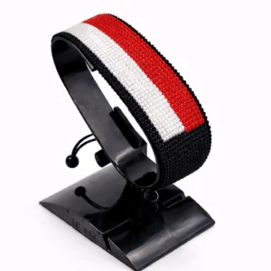 Handcrafted Yemen flag bracelet made with red, white, and black beads, adjustable beaded wrist accessory, displayed on a black stand.