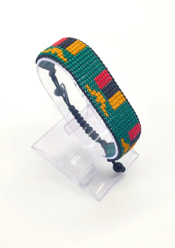 Handcrafted Zambia flag bracelet made with fine beads in green, red, black, and orange, adjustable beaded wrist accessory, displayed on a Clear stand.